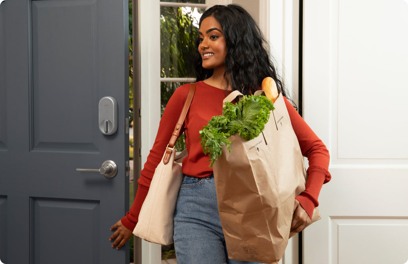 woman with groceries closing the door